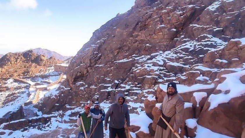 أبناء قبيلة الجبالية يقومون بإزالة الثلوج من طريق جبل موسي
