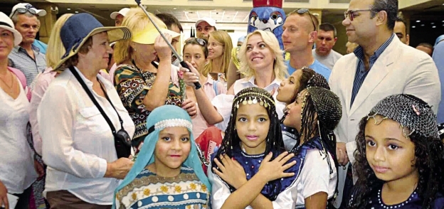 أطفال الأقصر يتوسطون سياحاً أثناء الاحتفال بيوم السياحة