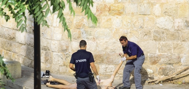 الشرطة الإسرائيلية تعاين جثة شهيد فلسطينى بعد قتله «أ. ف. ب»