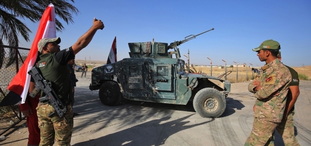 جنود عراقيون يلتقطون صورة «سيلفى» احتفالاً باستعادة «كركوك» «أ. ف. ب»
