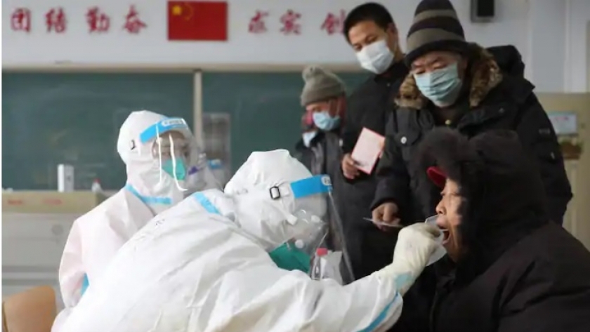 طبيب صيني يجري مسحة للحلق لأحد مرضى فيروس كورونا