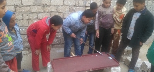 أطفال المنيا يمارسون البلياردو بطريقتهم الخاصة