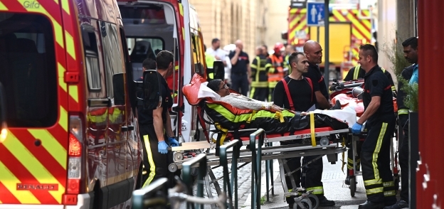 عمال الطوارئ ينقلون أحد المصابين إلى سيارة الإسعاف بعد انفجار عبوة ناسفة في ليون الفرنسية- تصوير أ ف ب