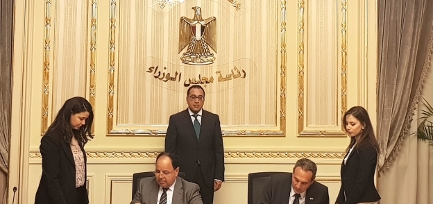 وزير المالية ومحمد الإتربى خلال التوقيع