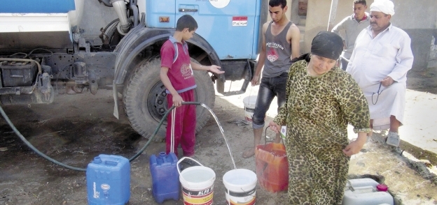 مواطنون أثناء ملء «جراكن» بعد تفاقم أزمة العطش