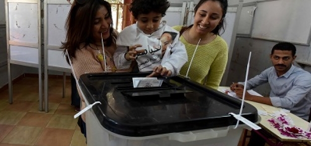 طفل يضع بطاقة تصويت والدته فى صندوق الاقتراع