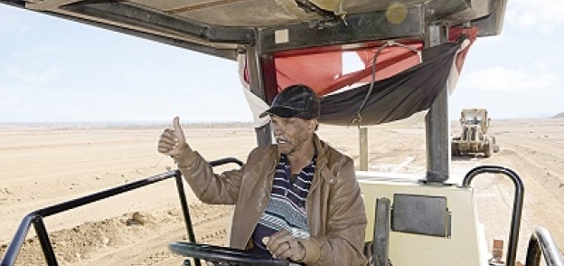 «صلاح» أثناء عمله على سيارته الضخمة لتسوية الرمال