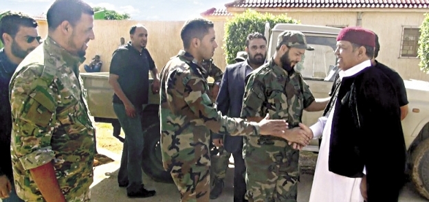 أحد مشايخ ليبيا يصافح عدداً من جنود