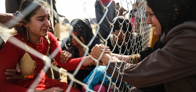 عراقيات غادرن «الموصل» بعد وصولهن إلى مخيم لاجئين بالقرب من أربيل 