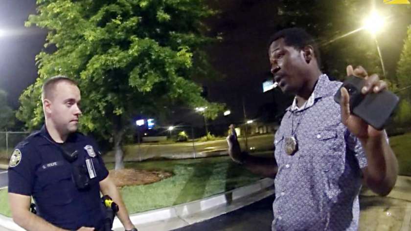 الأمريكى ريتشارد بروكس يتحدث مع ضابط شرطة قبل مقتله