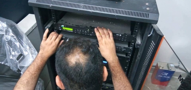 عامل بمستشفى دمنهور يجهز ماكينة الإذاعة الداخلية لإذاعة السلام الوطنى