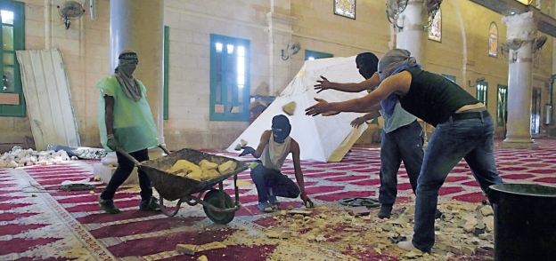 عدد من الفلسطينيين يجهزون «الحجارة» للدفاع عن المسجد الأقصى «أ.ف.ب»