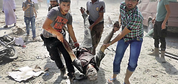 مواطنون سوريون أثناء نقل جثة أحد ضحايا القصف التركى «أ.ف.ب»