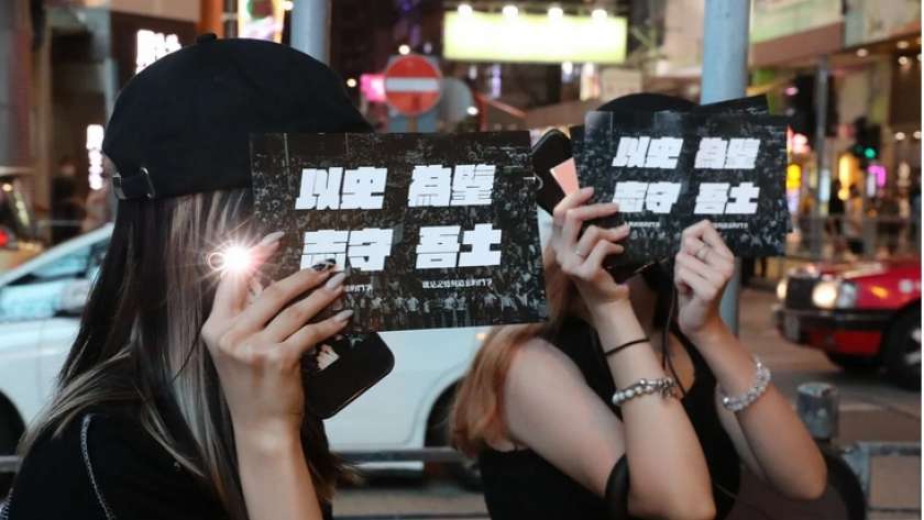 العشرات في هونج كونج يضيئون هواتفهم إحياء للذكرى «تيان أنمين»