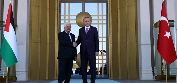 الرئيس التركي رجب طيب أردوغان يصافح نظيره الفلسطيني محمود عباس أبو مازن اليوم الإثنين خلال مراسم الاستقبال