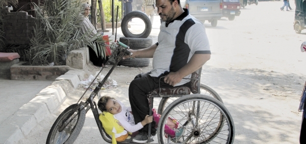 «خالد» وابنته «جنى» فى الدراجة المجهزة فى طريقهما للحضانة