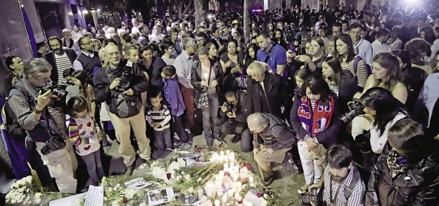 فرنسيون أثناء تأبين ضحايا هجمات باريس الإرهابية «أ.ف.ب»