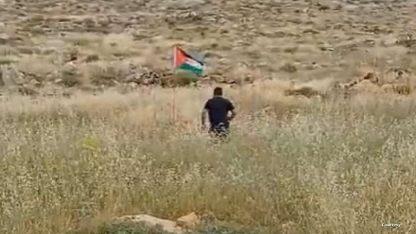 إسرائيلي حاول إزالة علم فلسطين المغروس على الأرض