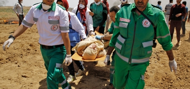 فلسطينيون يحملون جثمان أحد الشهداء الذين سقطوا بنيران قوات الاحتلال «أ. ف. ب»
