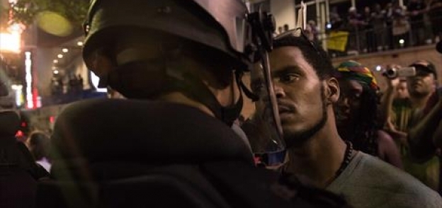 متظاهر يواجه رجل شرطة