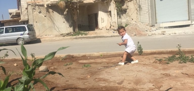 طفل سوري يلعب بين أطلال المنازل التي دمرتها الحرب