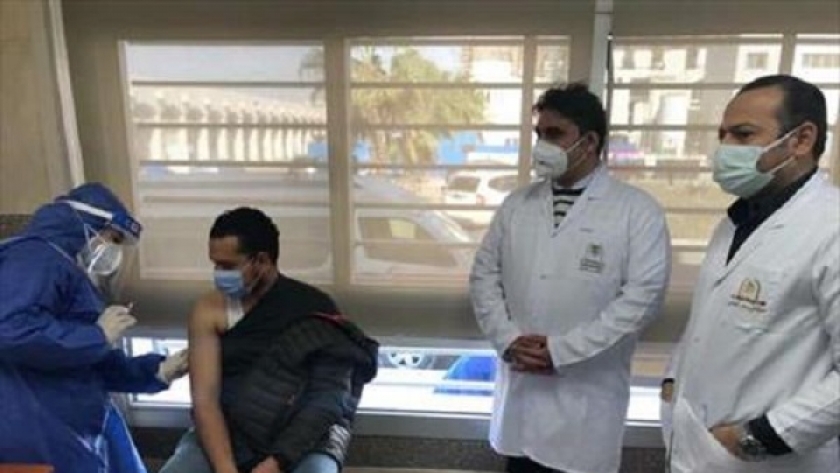 أحد أفراد الفرق الطبية خلال أخذ جرعة تطعيم ضد «كورونا»