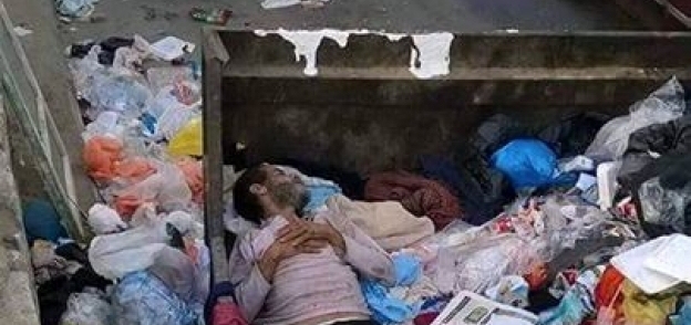 نشطاء يتداولون صورة لشخص ينام داخل صندوق قمامة بالإسكندرية