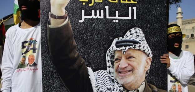 فلسطينيان من حركة فتح يرفعان صورة ياسر عرفات