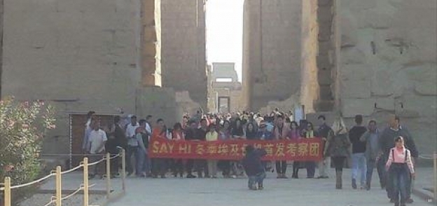 صينيون يرفعون لافتة " الشعب الصيني يدعوا العالم لزيارة الأقصر"