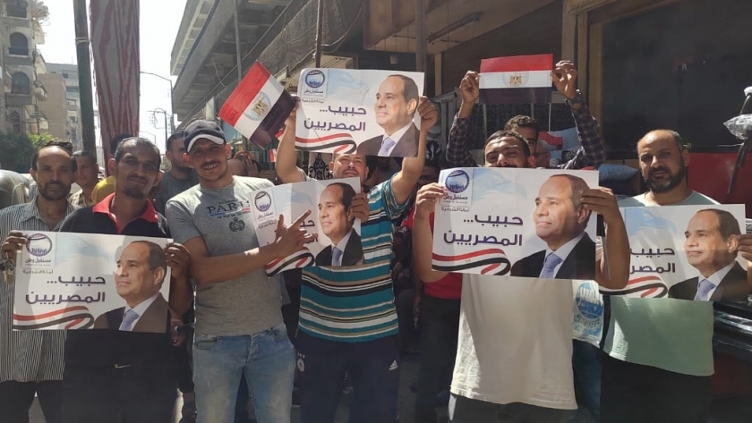 مواطنون يرفعون صور الرئيس عبد الفتاح السيسي
