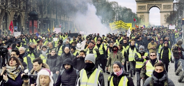 متظاهرو السترات الصفراء فى مسيرة بالقرب من قوس النصر فى باريس «أ.ف.ب»
