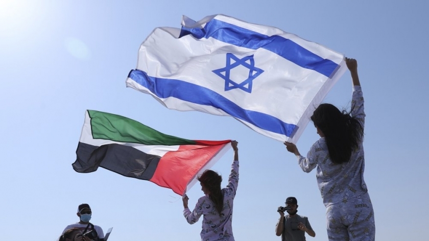 عارضة الأزياء الإسرائيلية ماي تاجر تغطي نفسها بعلم إسرائيل إلى جانب أنستازيا باندارينكا بعلم الإمارات