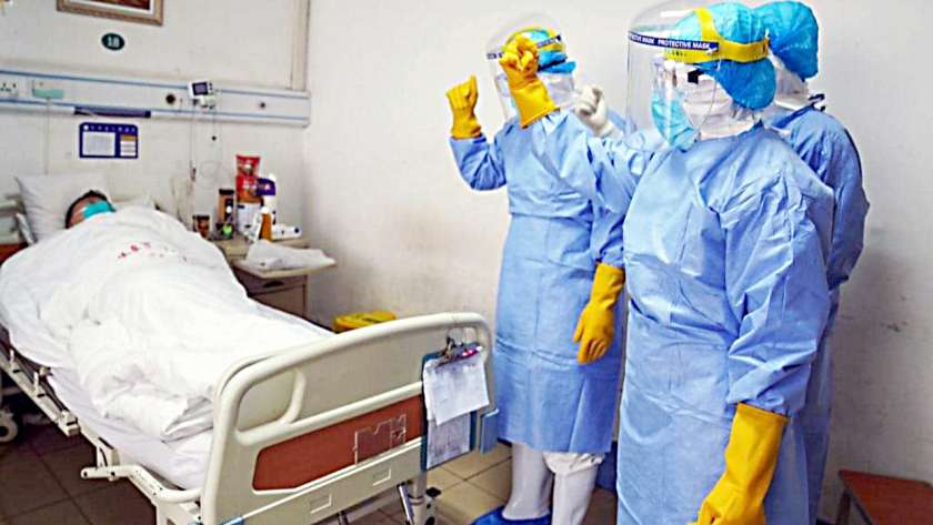 أطباء صينيون خلال معاينتهم لمصاب بفيروس كورونا