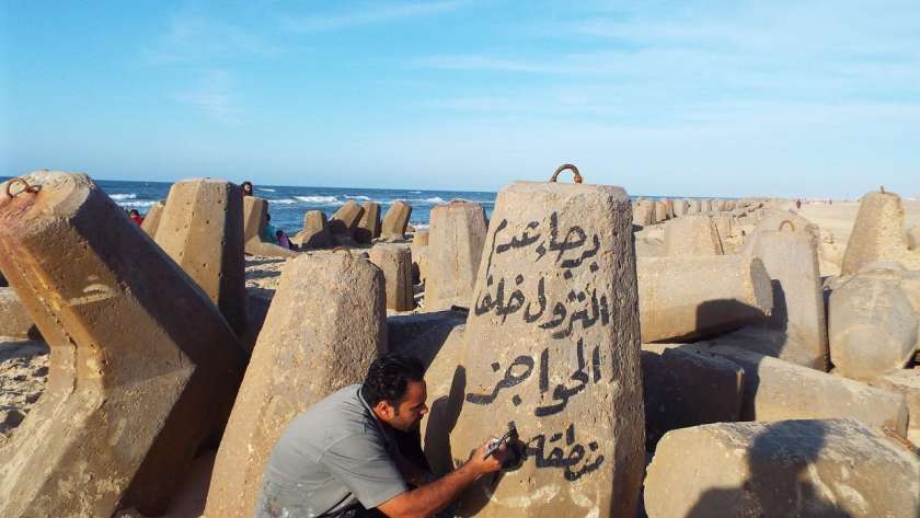 لافتات ارشادية وعبارات تحذيرية على الصخور بمصيف بلطيم