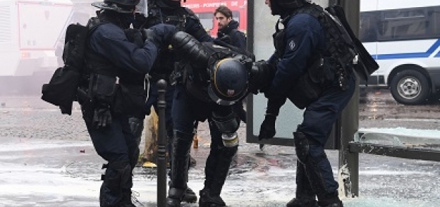عناصر من الشرطة الفرنسية يساعدون أحد زملائهم بعد الاصابة