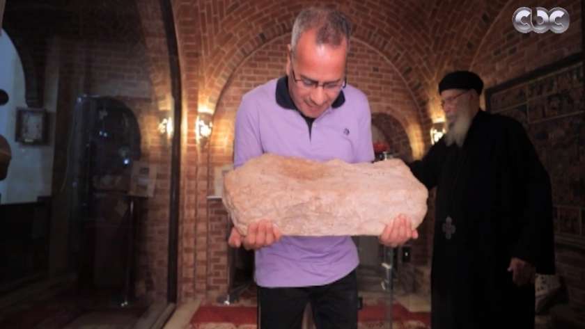الإعلامي جابر القرموطي يحمل الحجر المطبوع عليه قدم المسيح عليه السلام