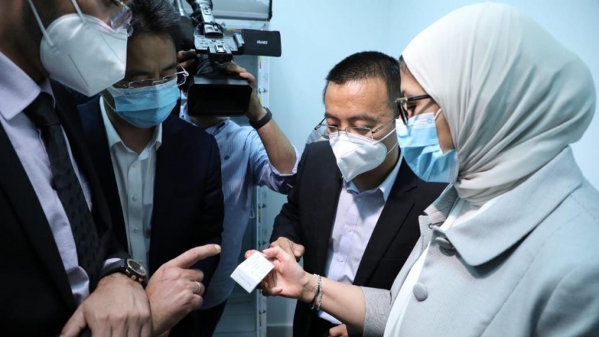 الدكتورة هالة زايد أثناء مسكها اللقاح الصيني