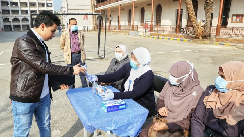توزيع الكمامات الطبية على الطلاب داخل اللجان الامتحانية
