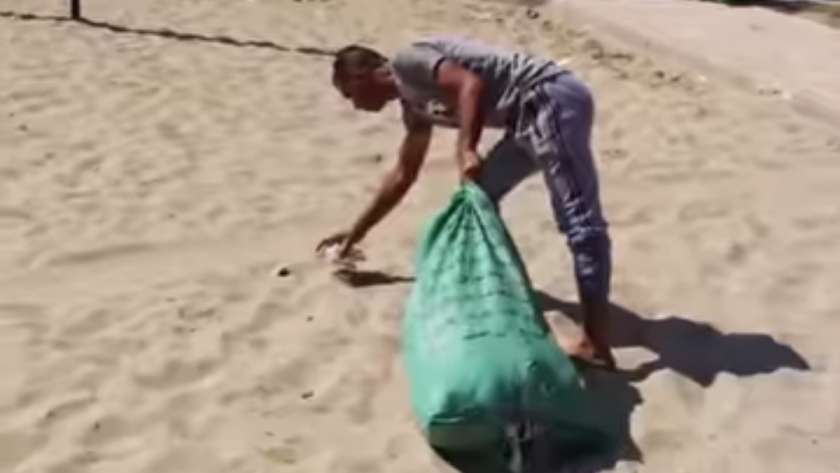 عامل نظافة على شاطئ بالإسكندرية