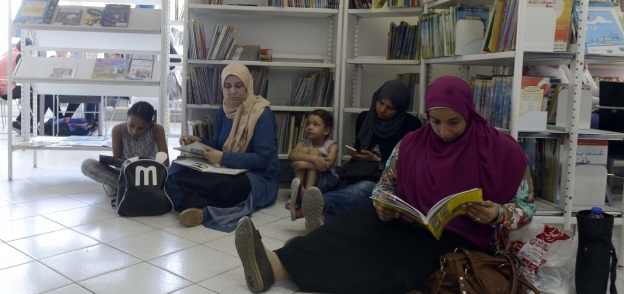 زحام الأطفال وضجيجهم يدفع بعض الزوار من الشباب إلى الجلوس على الأرض لمطالعة الكتب