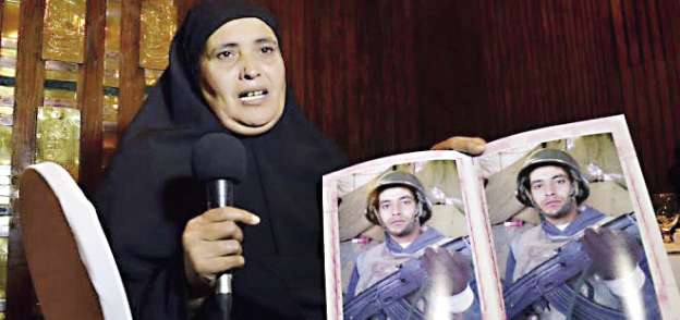 والدة شهيد الفرافرة تحمل صورة ابنها