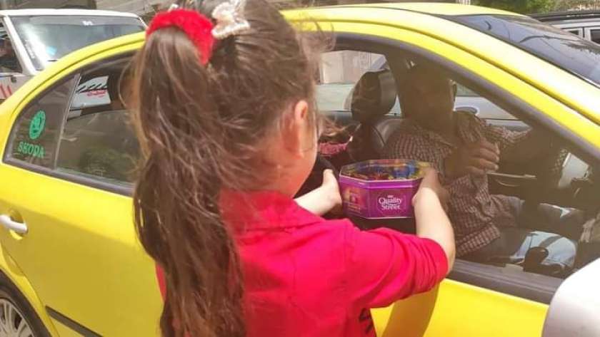 طفلة من مصابي التوحد توزع حلوى العيد على سائق