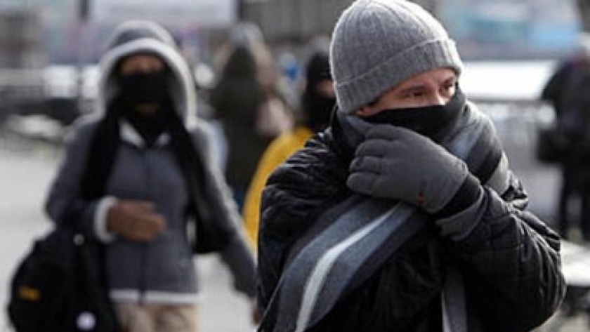 أشخاص يرتدون ملابس ثقيلة لحمايتهم من موجة الهواء البارد