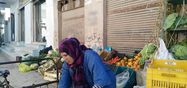 «حنان» تُحمل الخضروات على «التروسيكل» لبيعها فى السوق