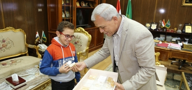 الطفل عبد الرحمن يقدم مصحف وسجادة صلاة هدية لمحافظ المنوفية