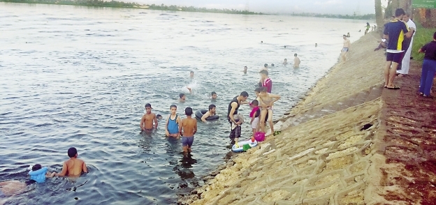 أطفال وكبار يسبحون فى النيل لتخفيف حرارة الجو