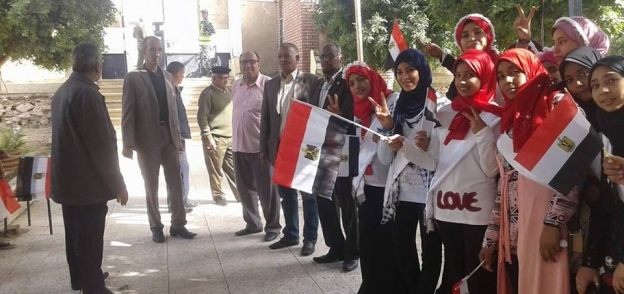 بالصور| طلاب إدارة دشنا التعليمية يستقبلون الناخبين بالأعلام والورود