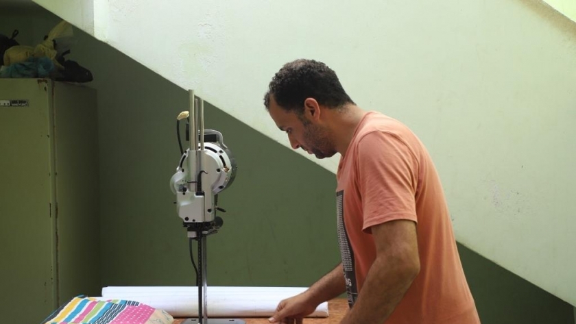 محمد متولي أثناء عمله في مصنع المفروشات