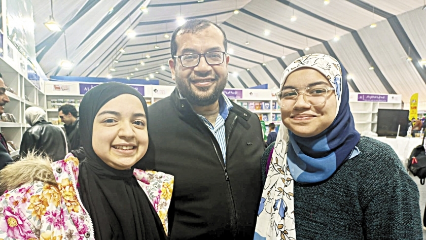 محمود رمضان مع ابنتيه «حبيبة ومريم» في المعرض