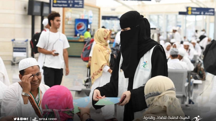إحدى المتطوعات خلال توعية الحجاج داخل صالة المطار